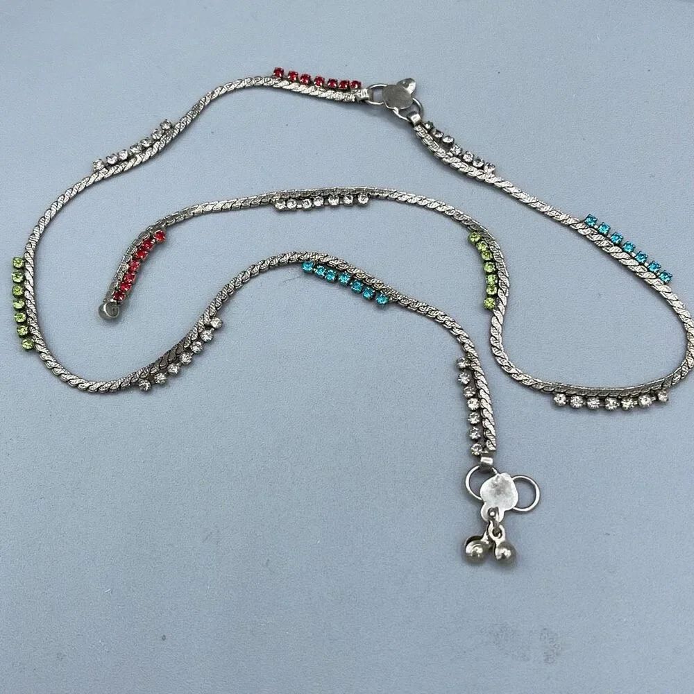 Vintage silver colored necklace with rhinestone sections .